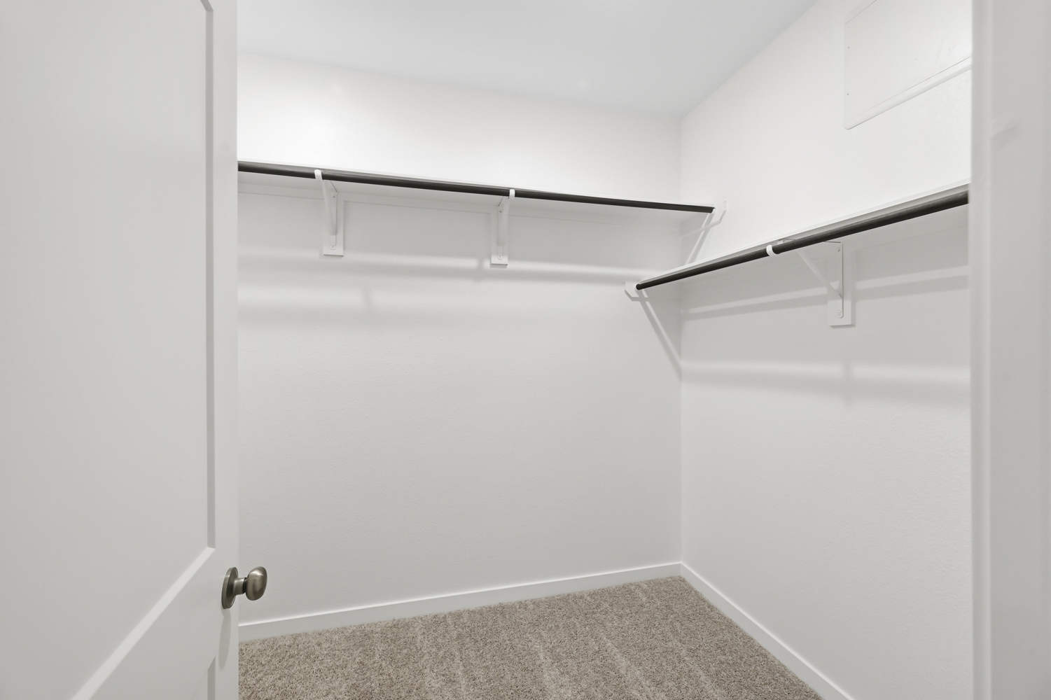 A white door with a metal bar.