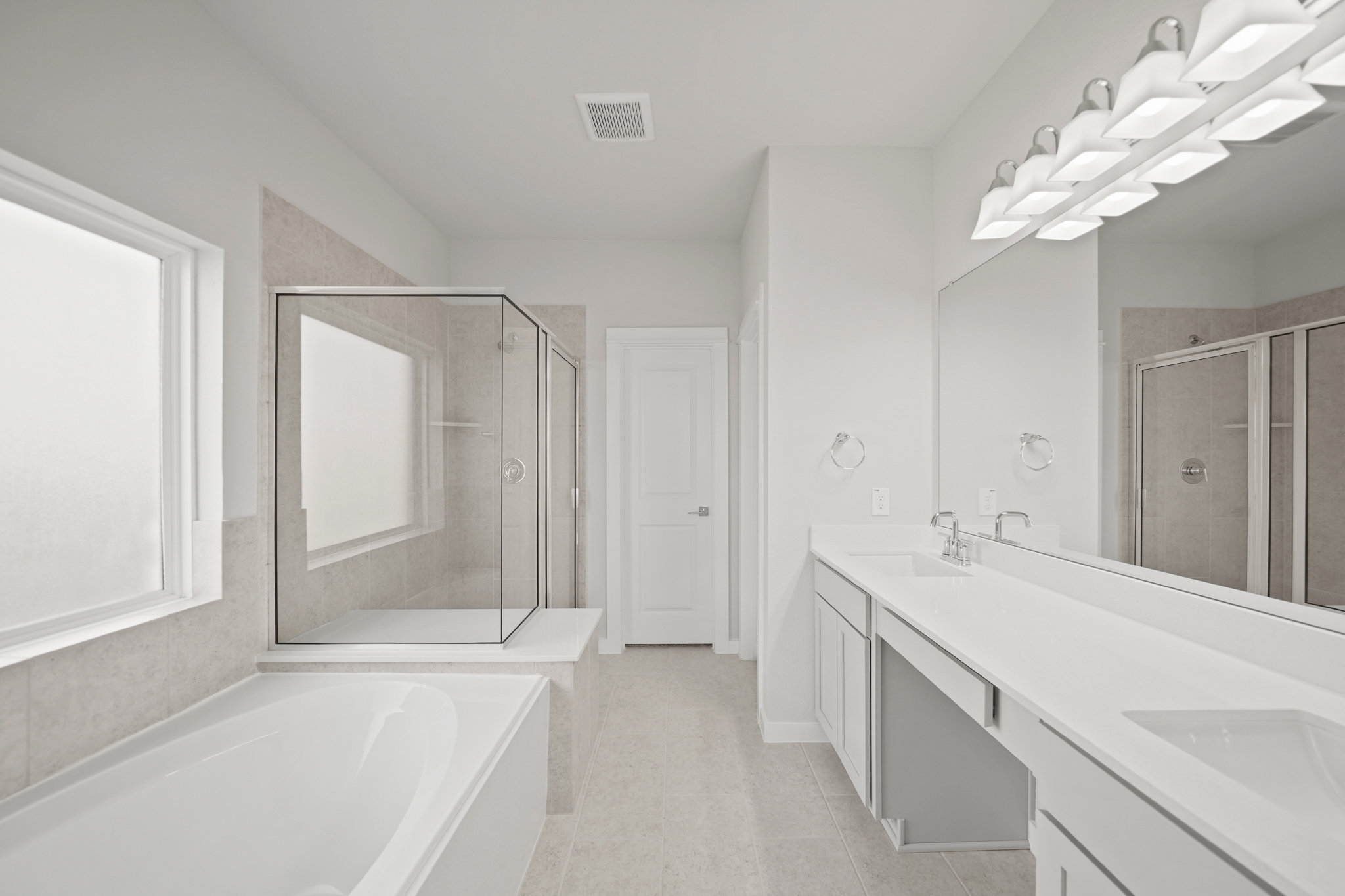 A bathroom with a tub sink and mirror.