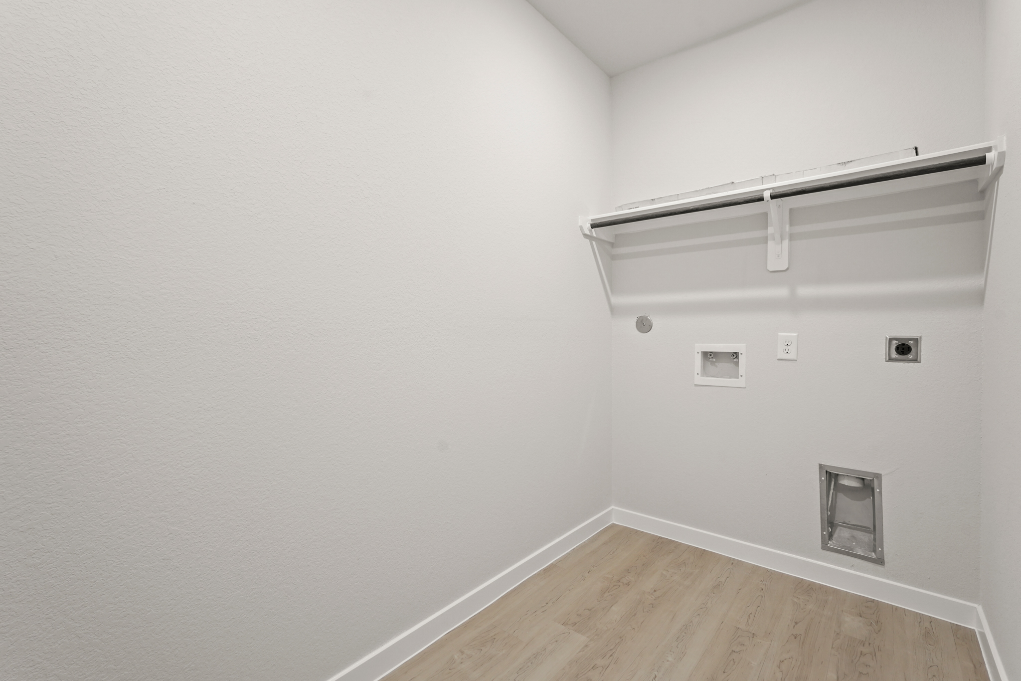 A white room with a wood floor.