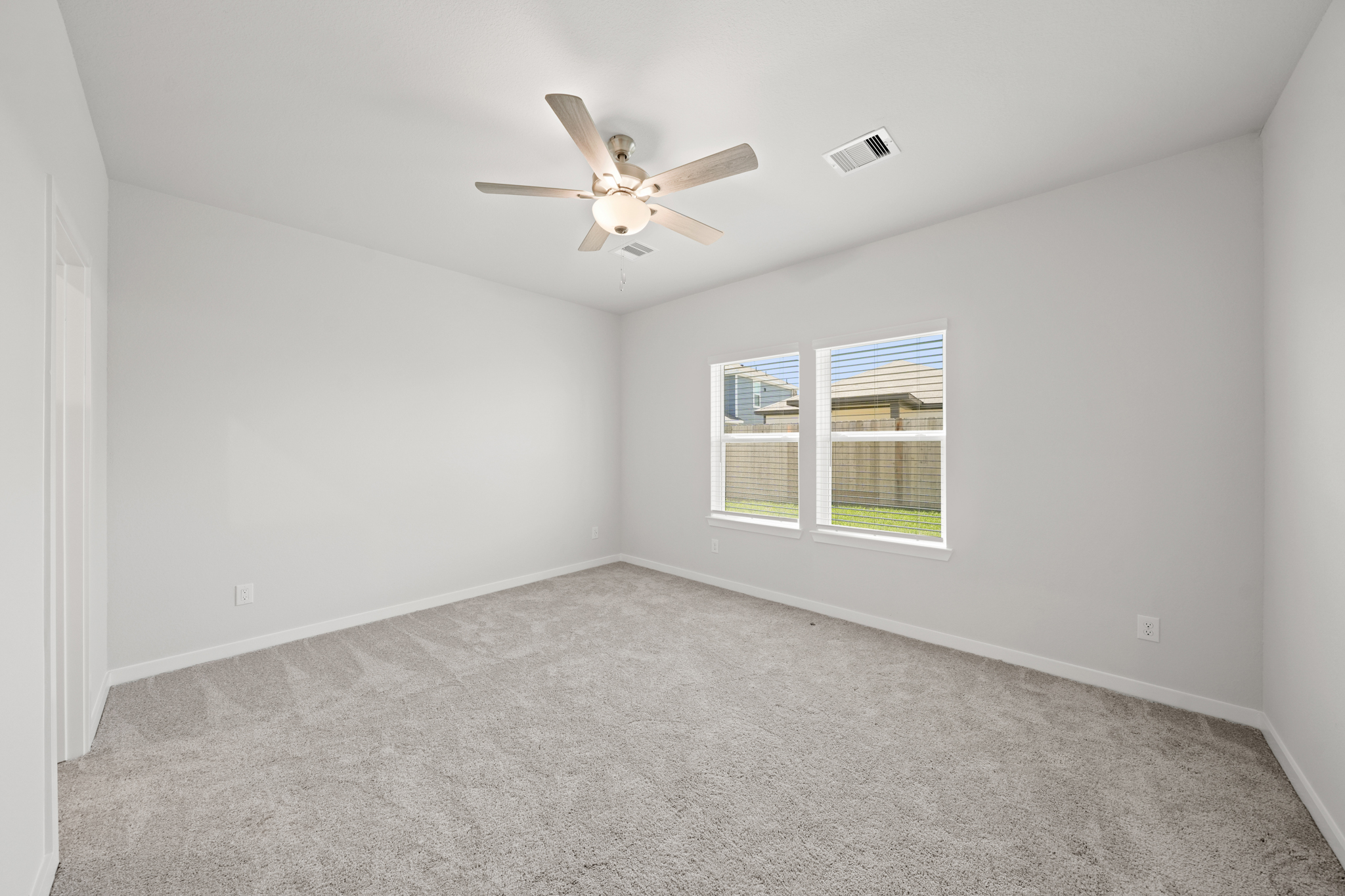 A room with a ceiling fan and a window.