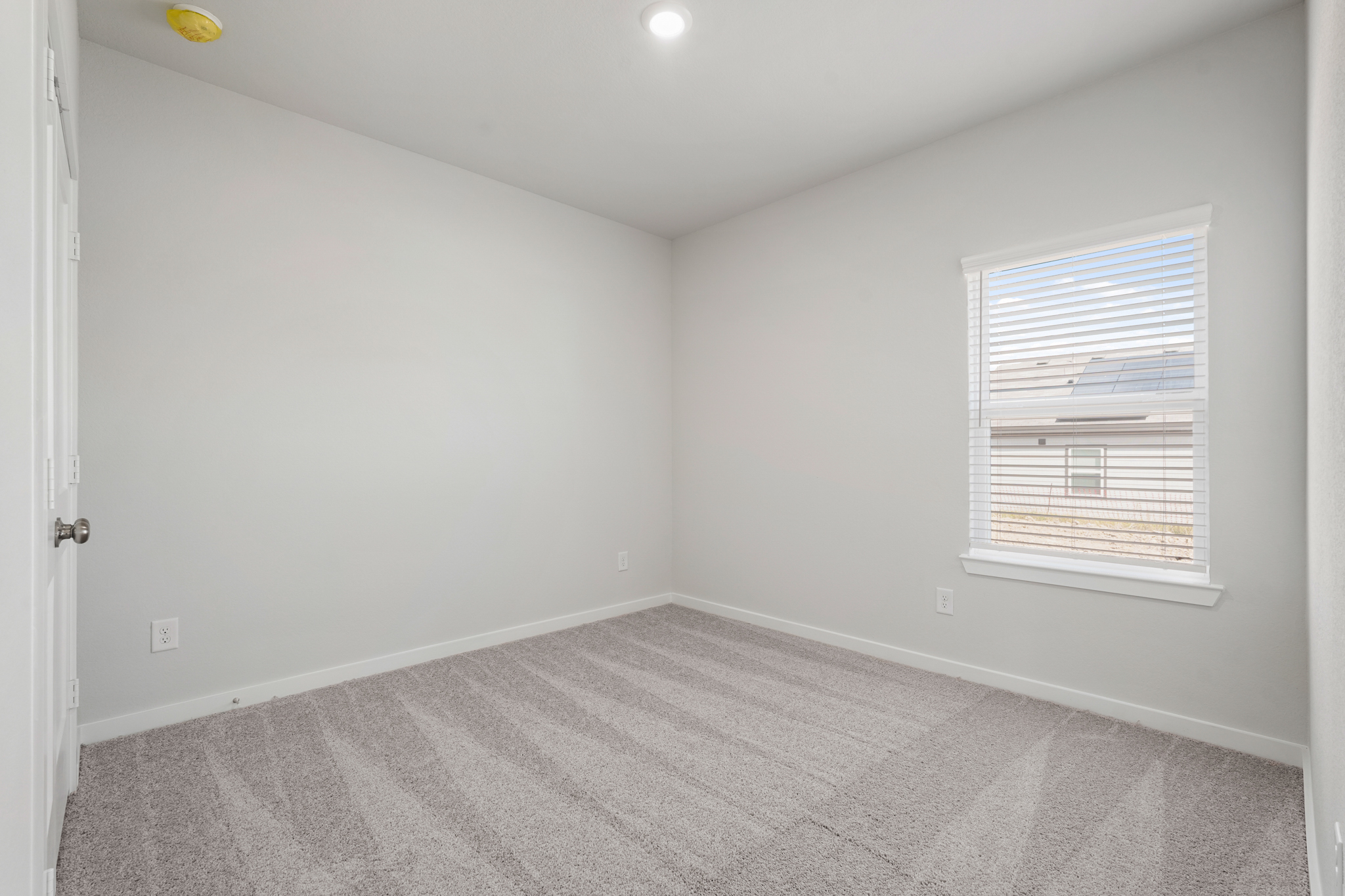 A room with a window and a carpet.