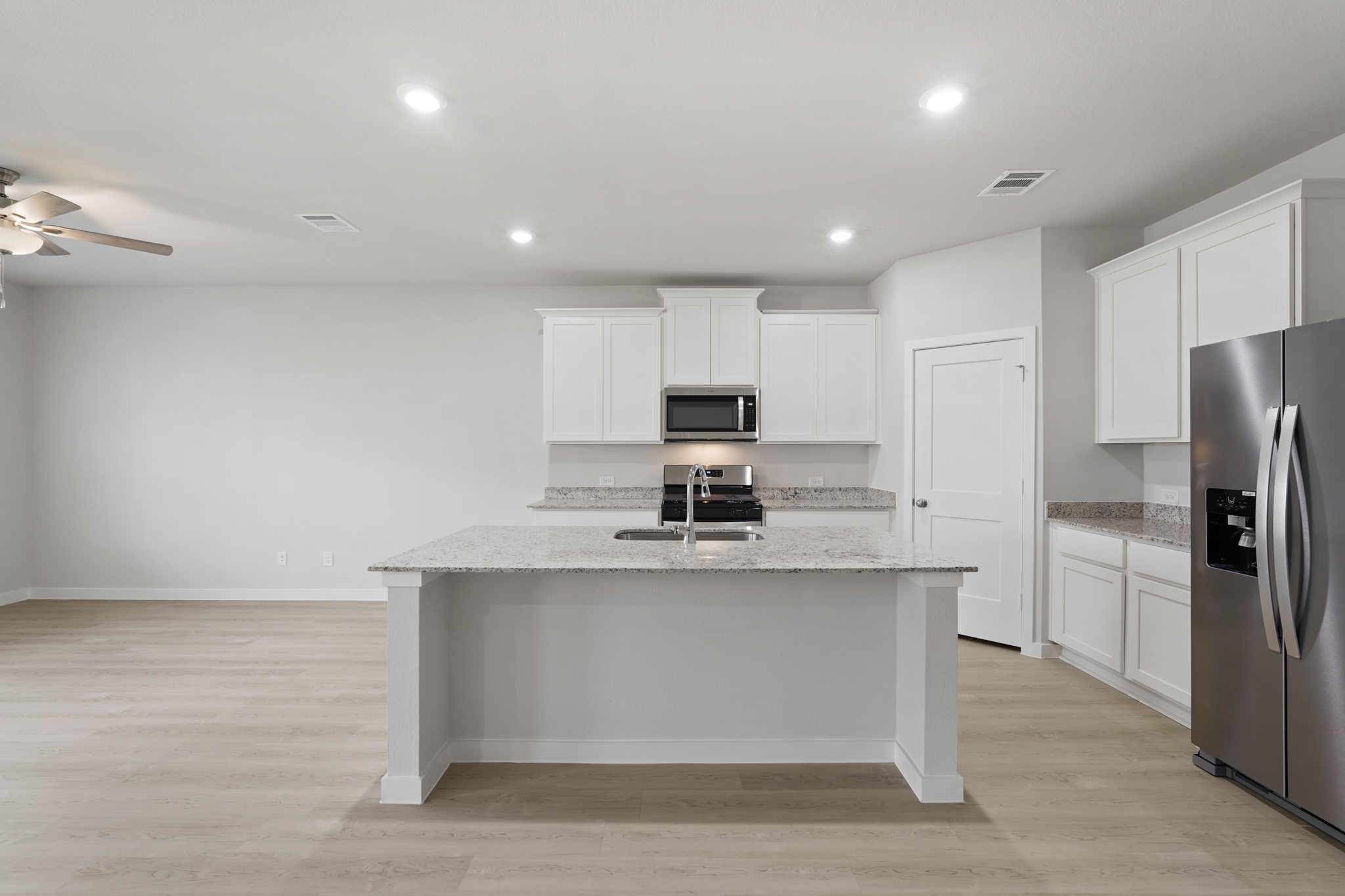 A kitchen with white cabinets.
