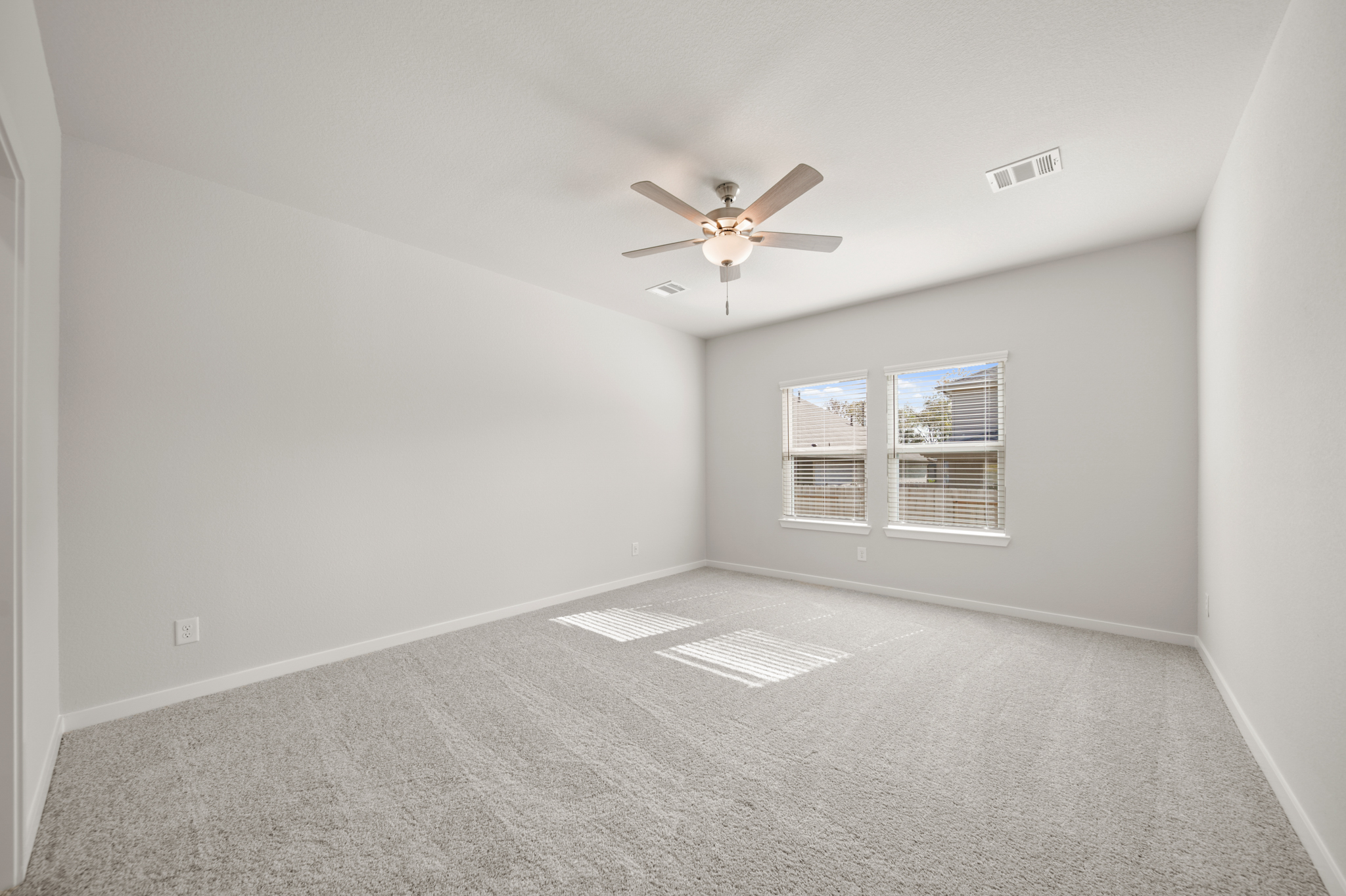 A room with a ceiling fan and a window.