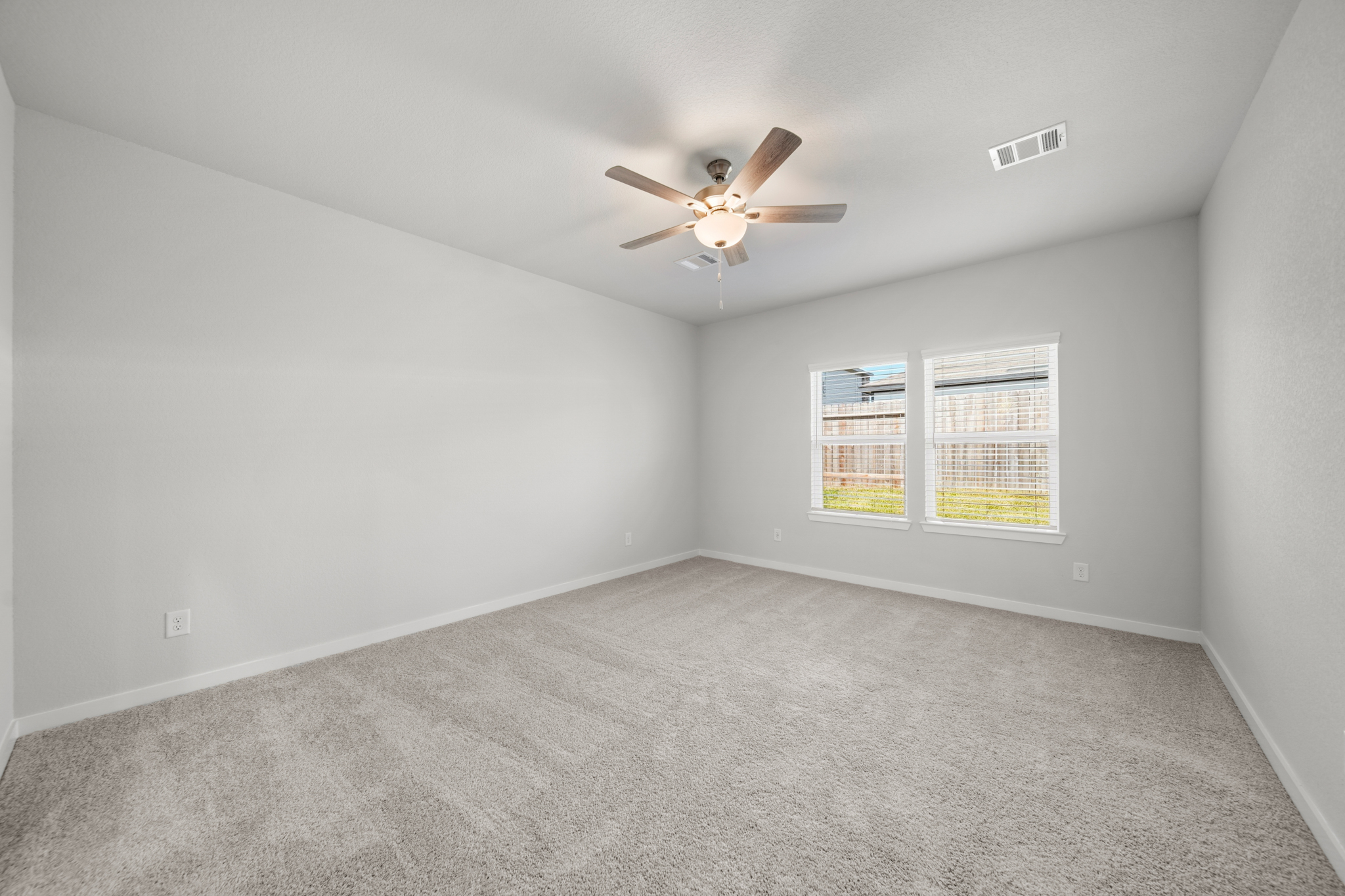 A room with a ceiling fan and a window.
