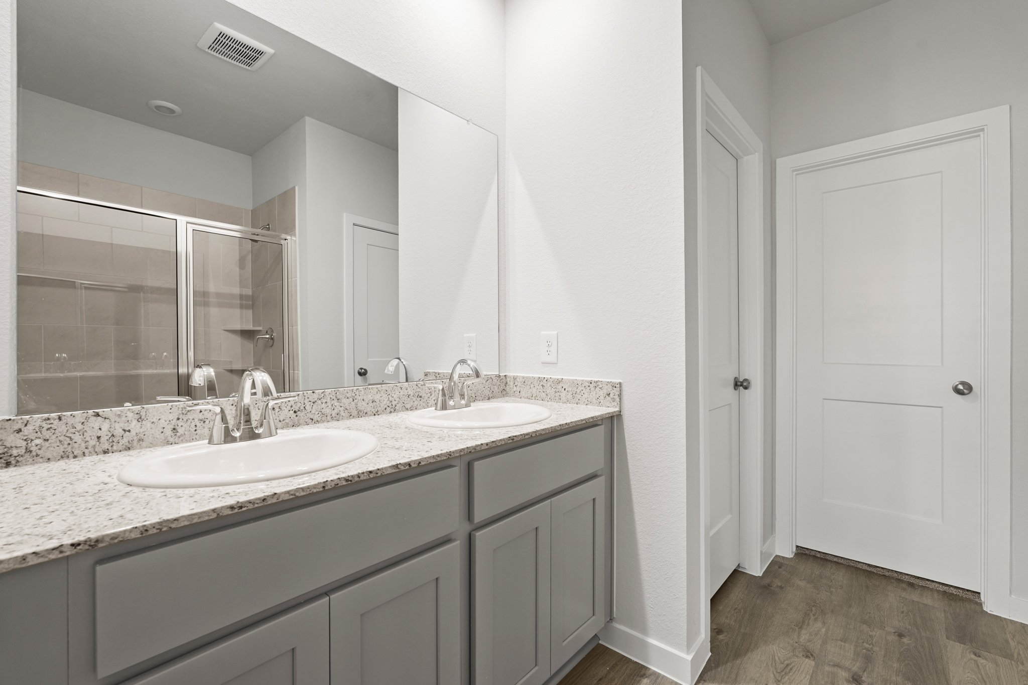 A bathroom with a large mirror.