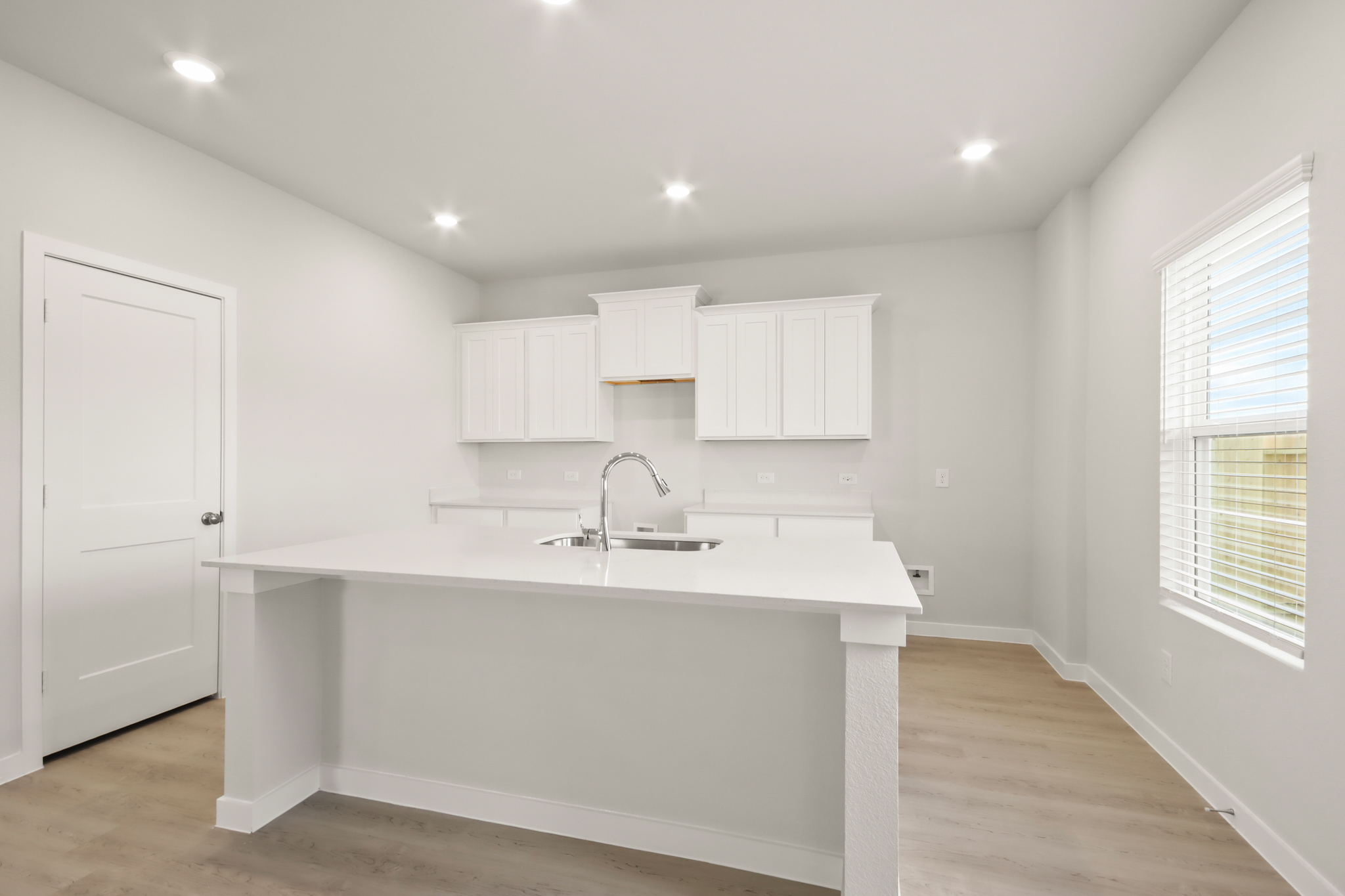 A kitchen with white cabinets.