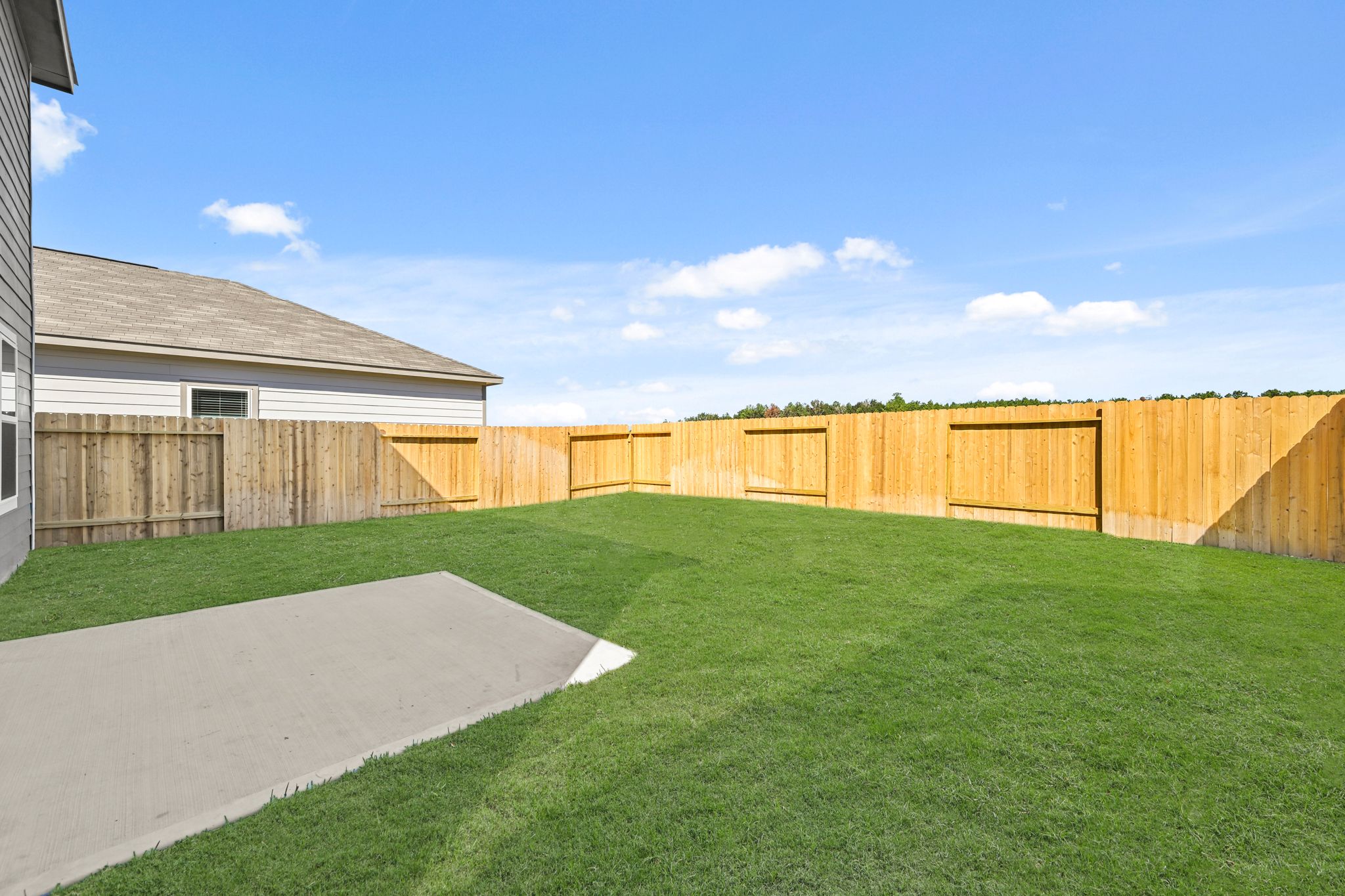 A fenced in yard with a house in the background with Nelson-Atkins Museum of Art in the background.