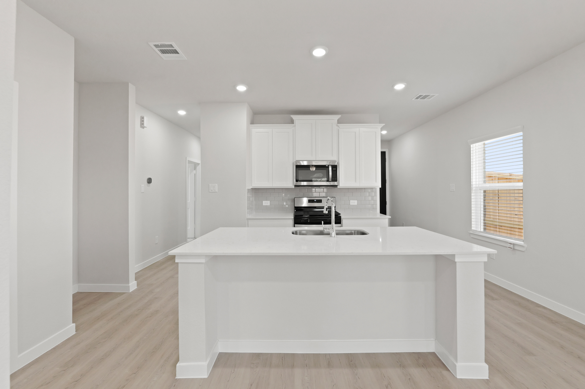 A kitchen with white cabinets.
