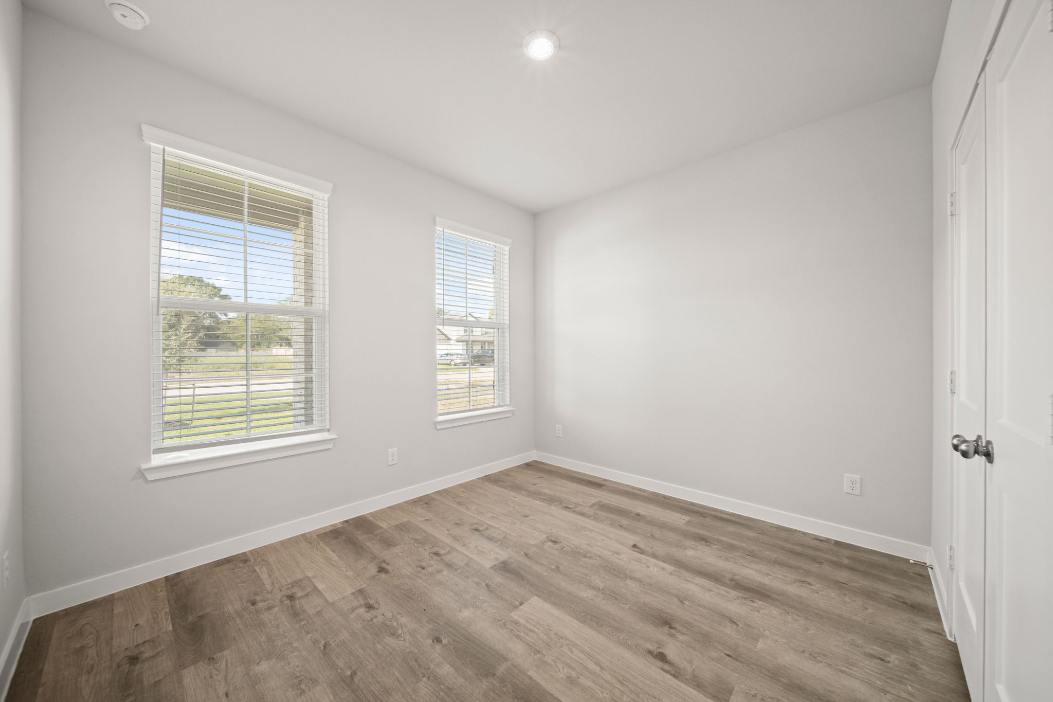A room with a wood floor and windows.