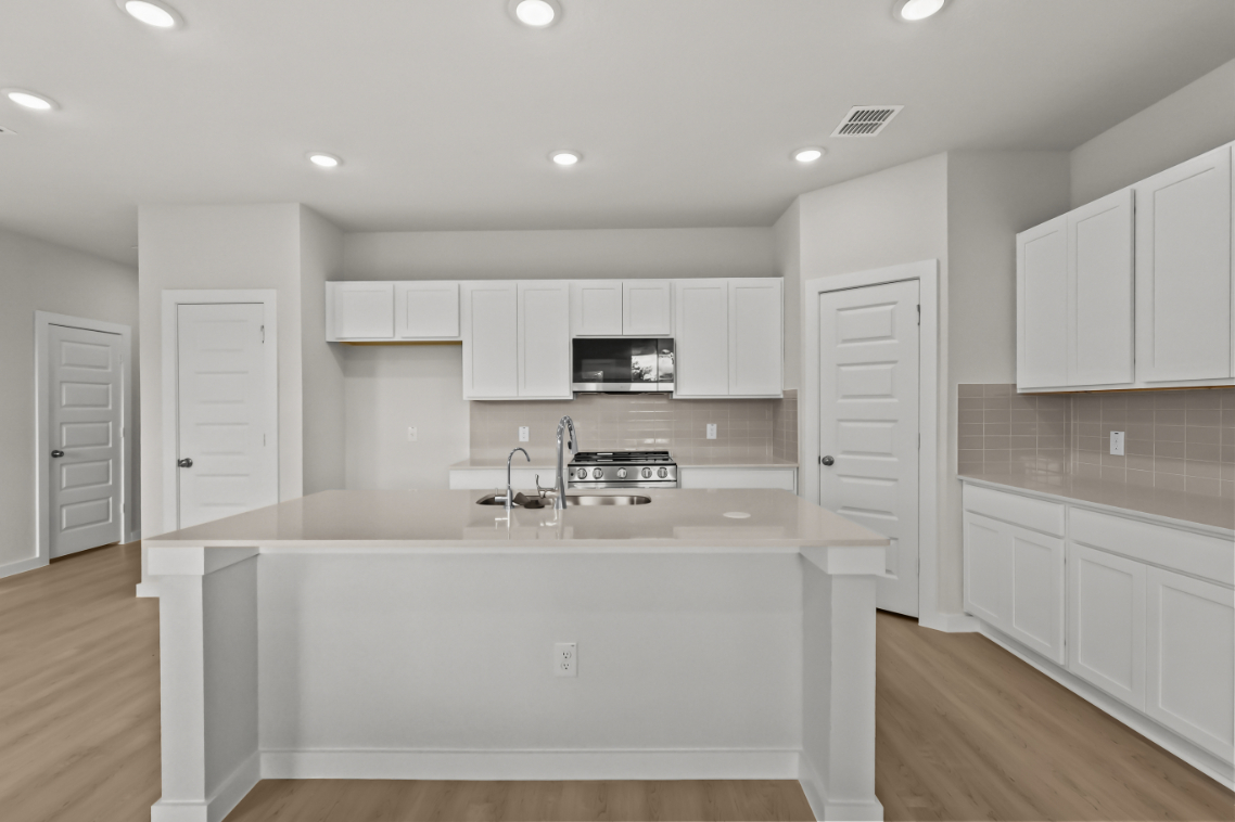 A kitchen with white cabinets.