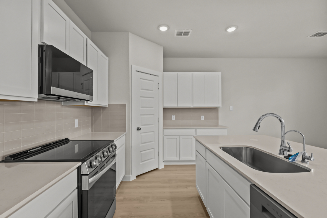A kitchen with white cabinets.