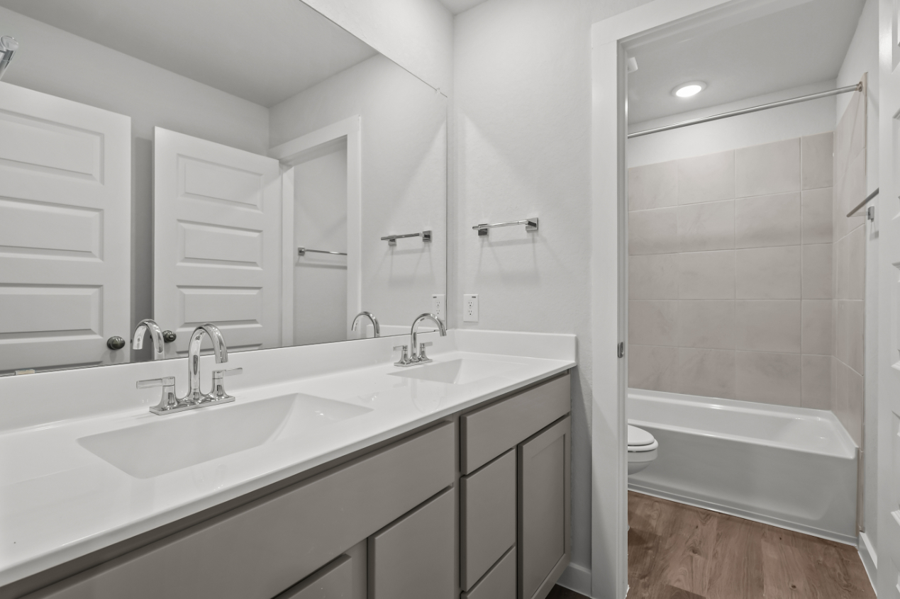 A bathroom with a sink and a shower unit.