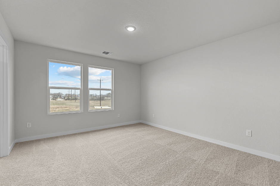 A room with a window and a painting on the wall.