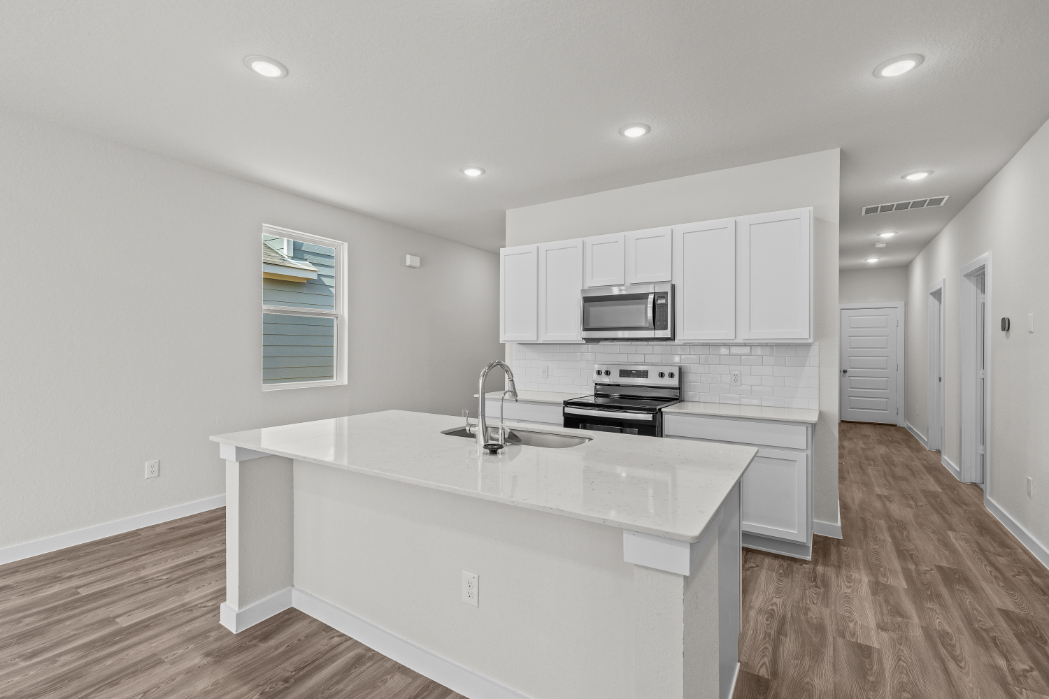 A kitchen with white cabinets.