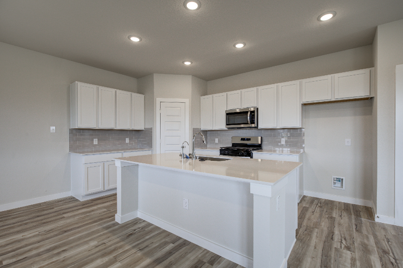 A kitchen with white cabinets.
