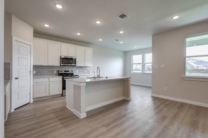 A kitchen with white cabinets.