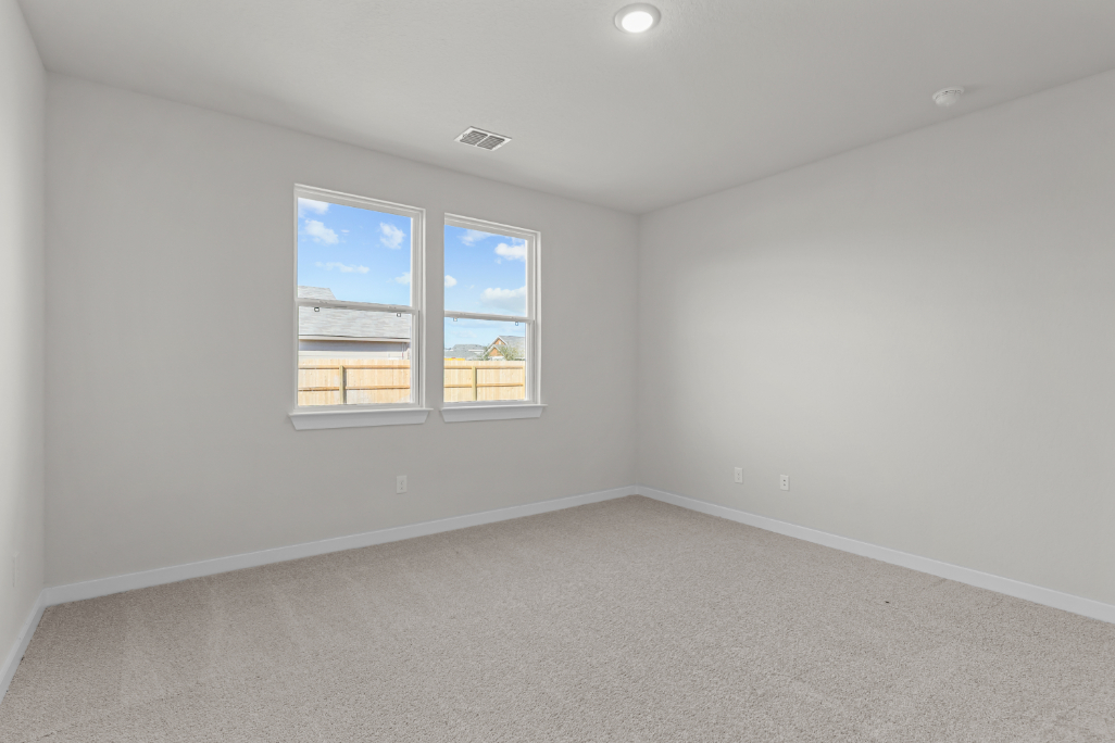 A room with a window and a white wall with a blue sky.