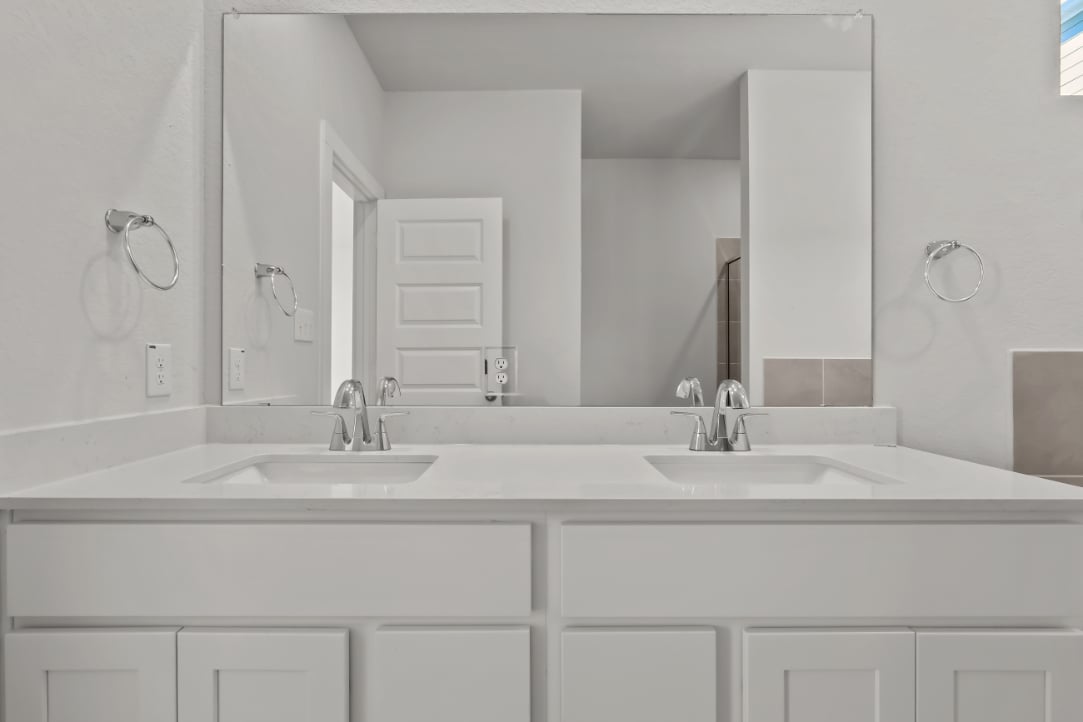 A bathroom with white cabinets.