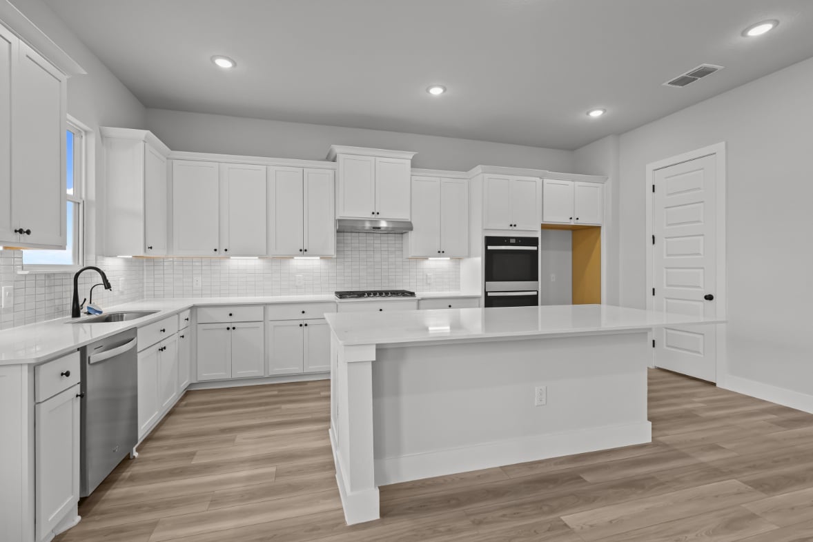 A kitchen with white cabinets.