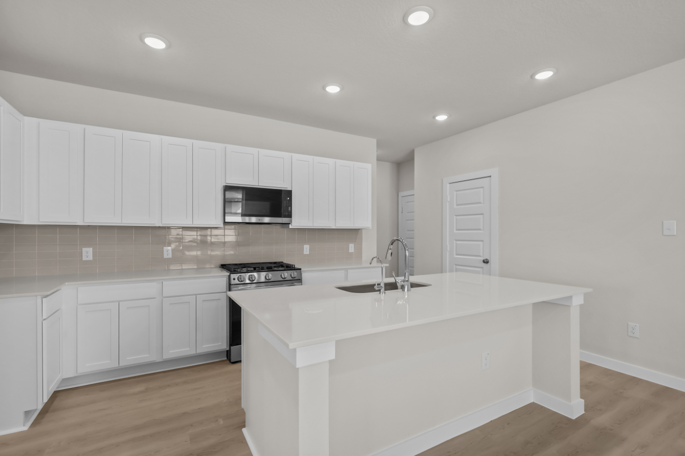 A kitchen with white cabinets.