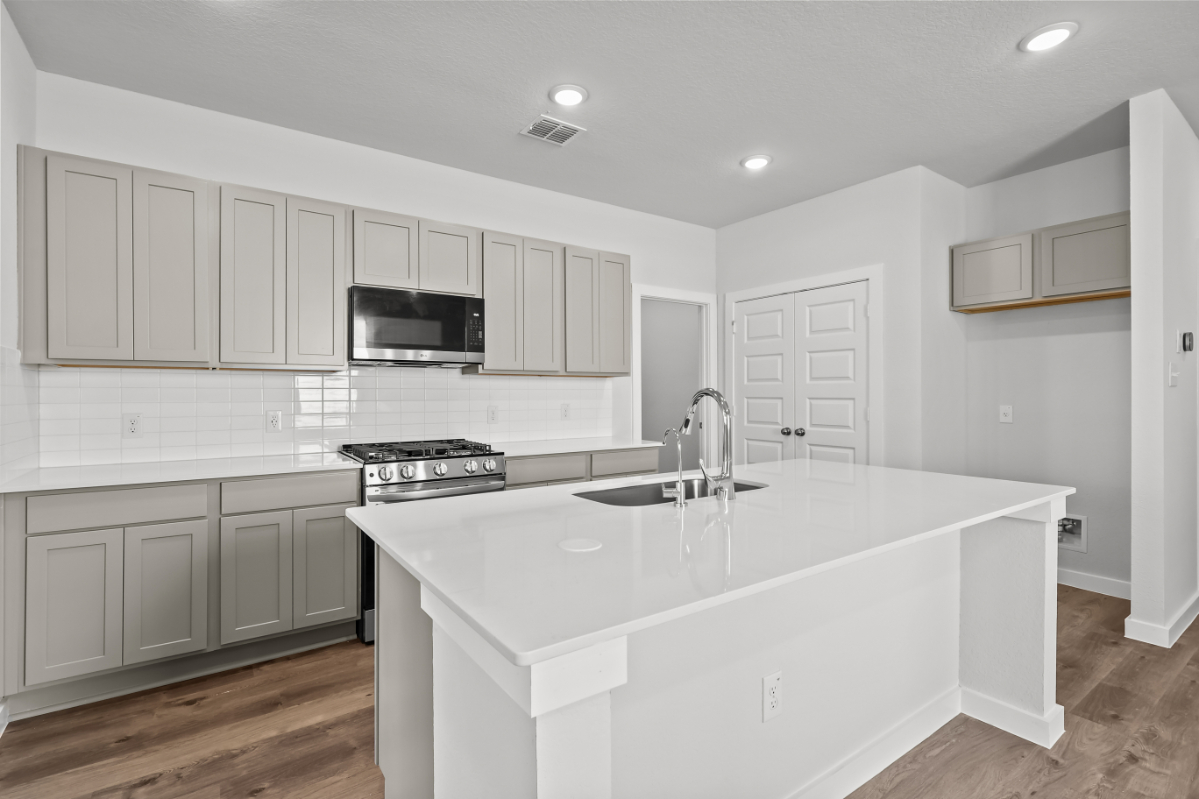 A kitchen with white cabinets.