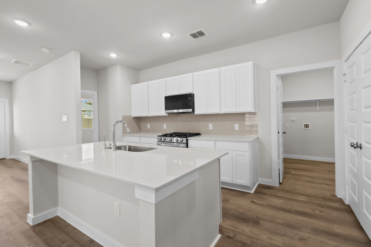 A kitchen with white cabinets.