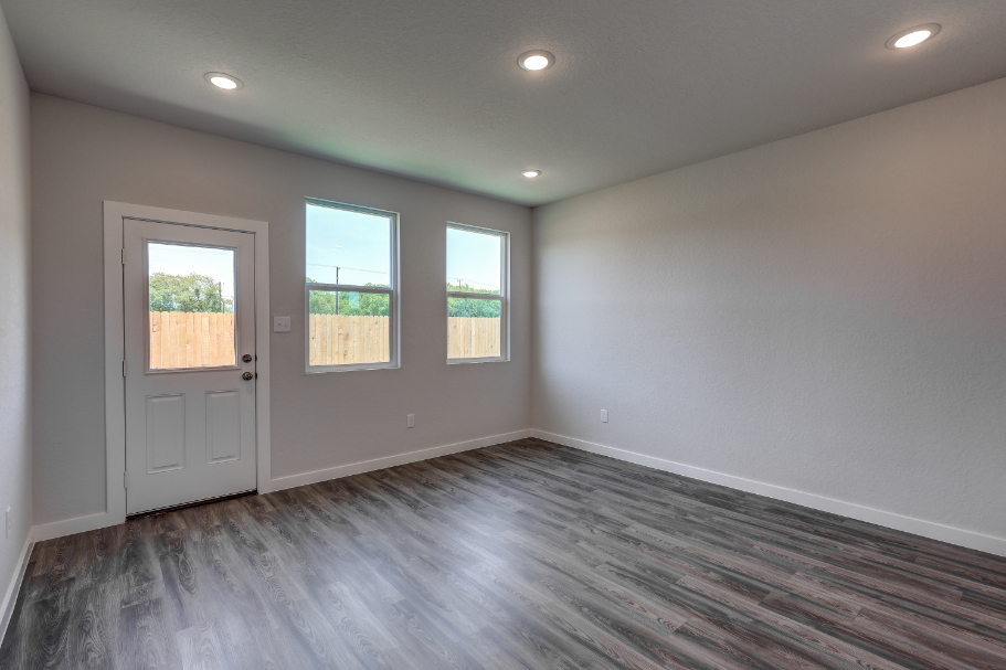 A room with a wood floor and windows.
