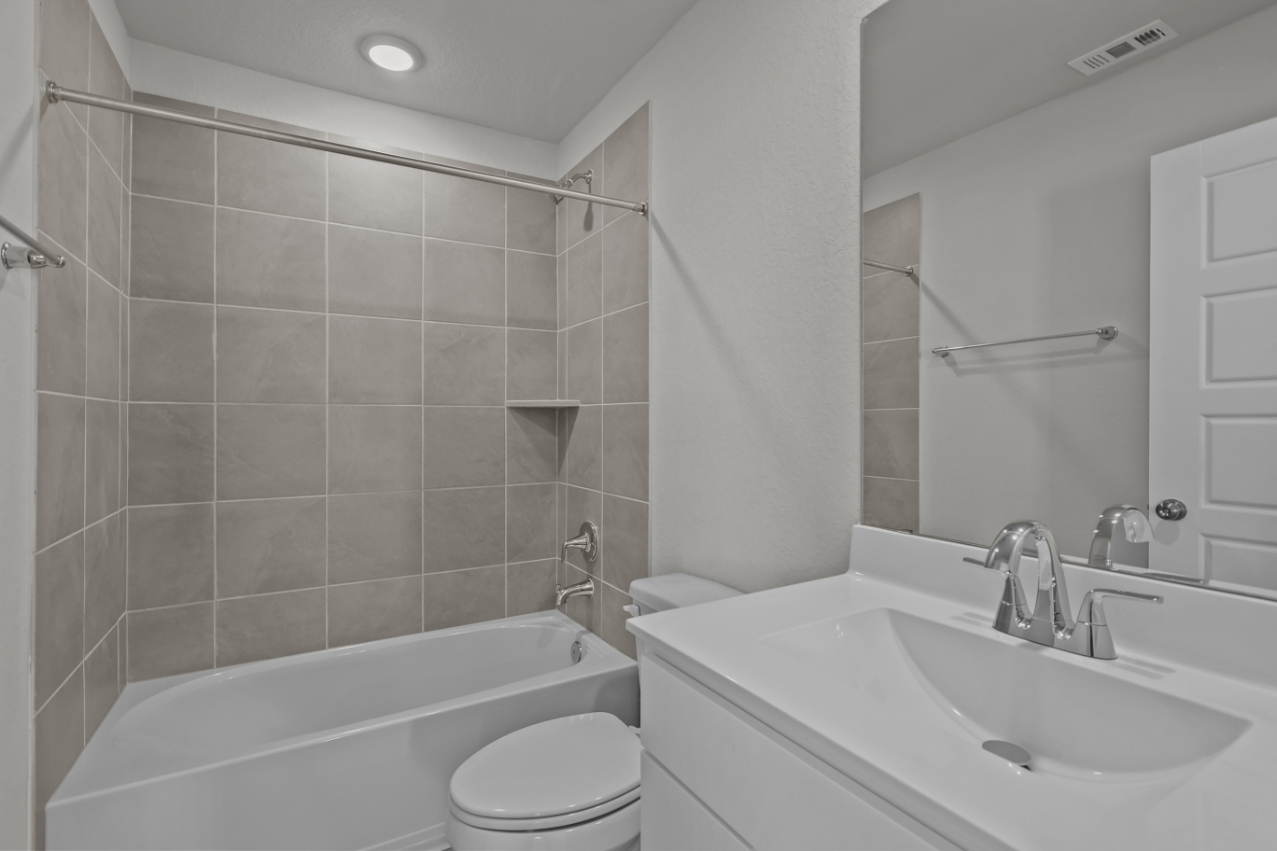 A bathroom with a tub sink and toilet.