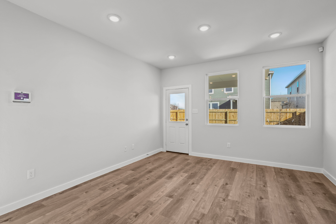 A room with white walls and a wood floor with a wood floor.