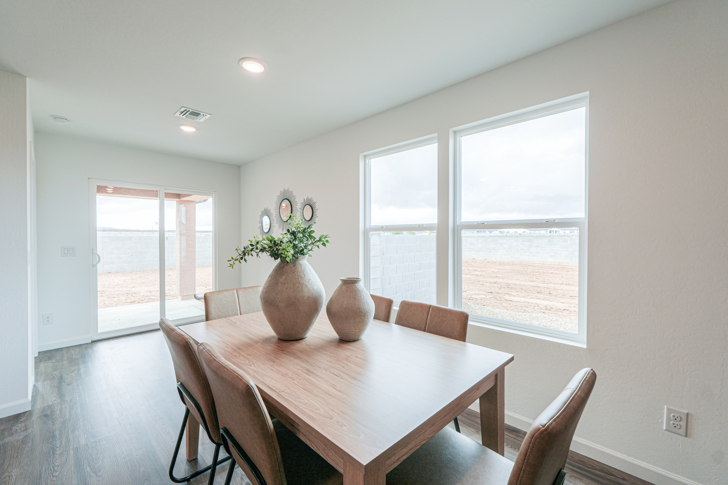 A dining room table with a vase of flowers on it.