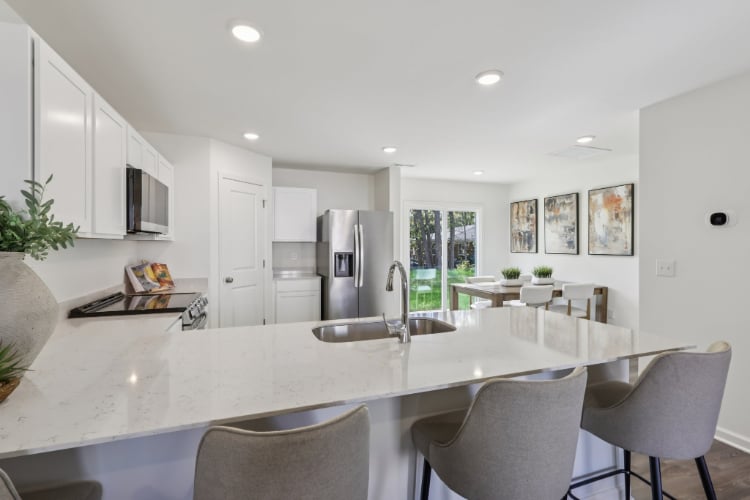 A kitchen with a dining table and chairs.
