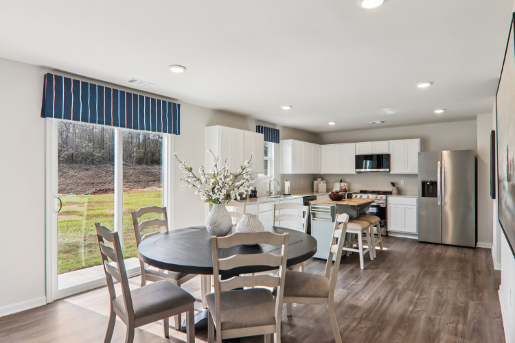 A kitchen with a dining table and chairs.