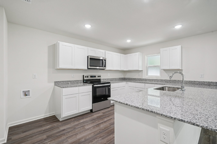 A kitchen with white cabinets.