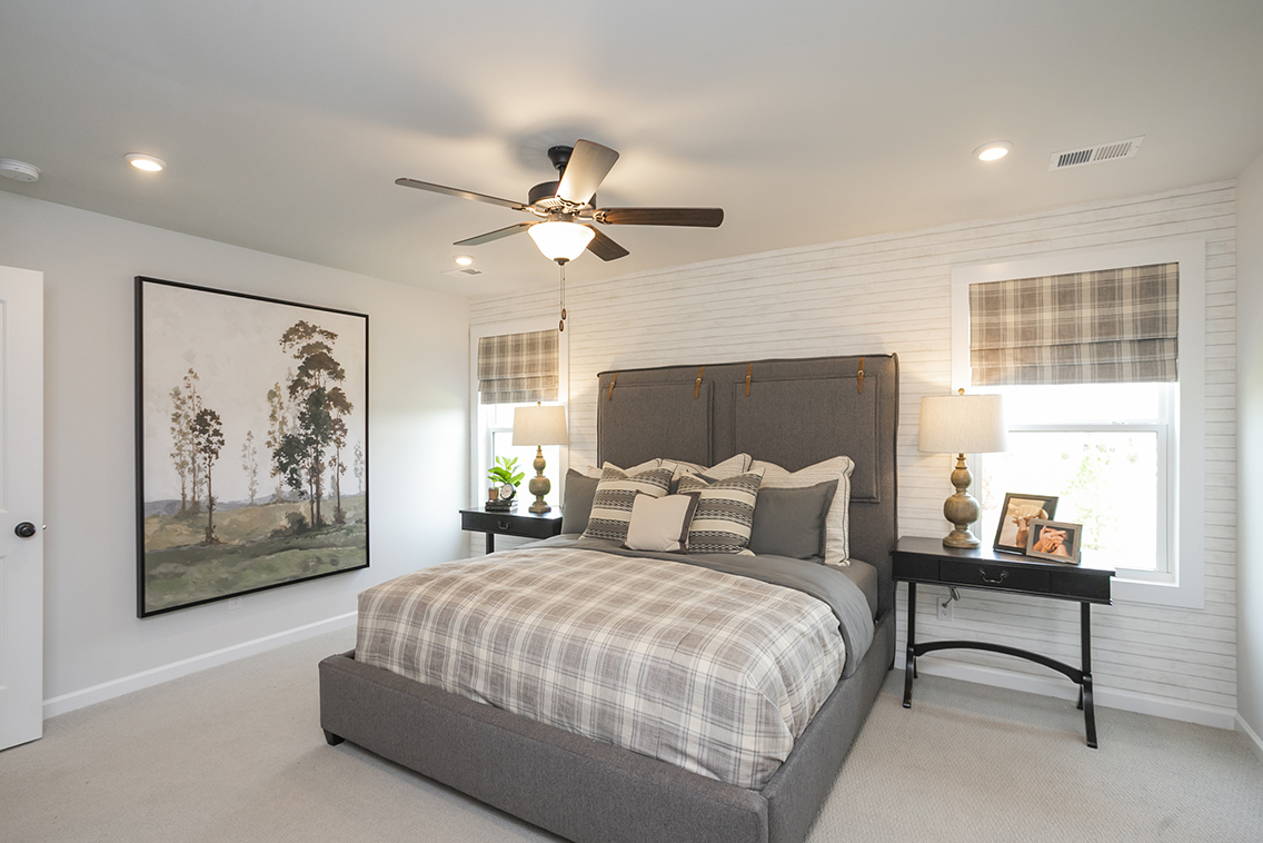 A bedroom with a bed and a fan.