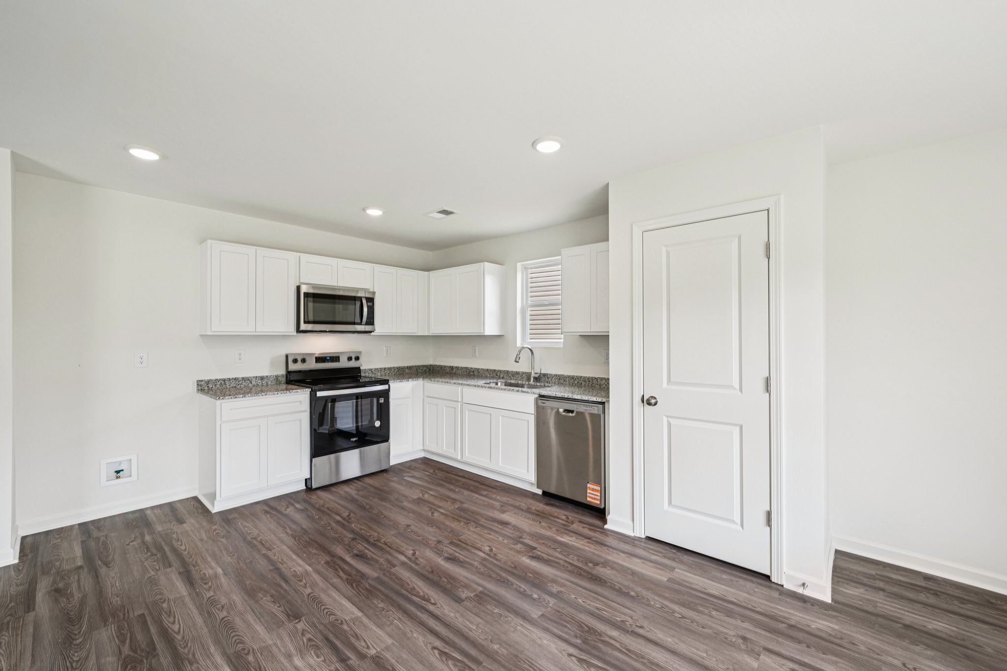 A kitchen with white cabinets.