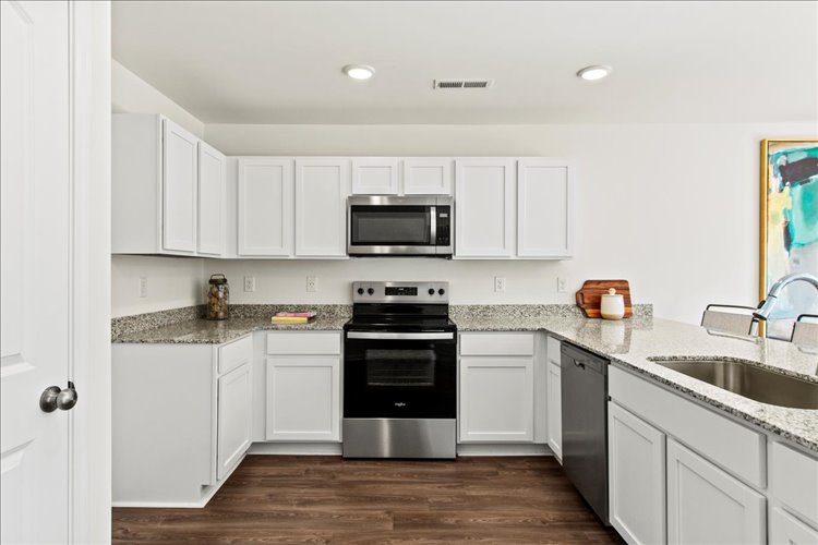 A kitchen with white cabinets.