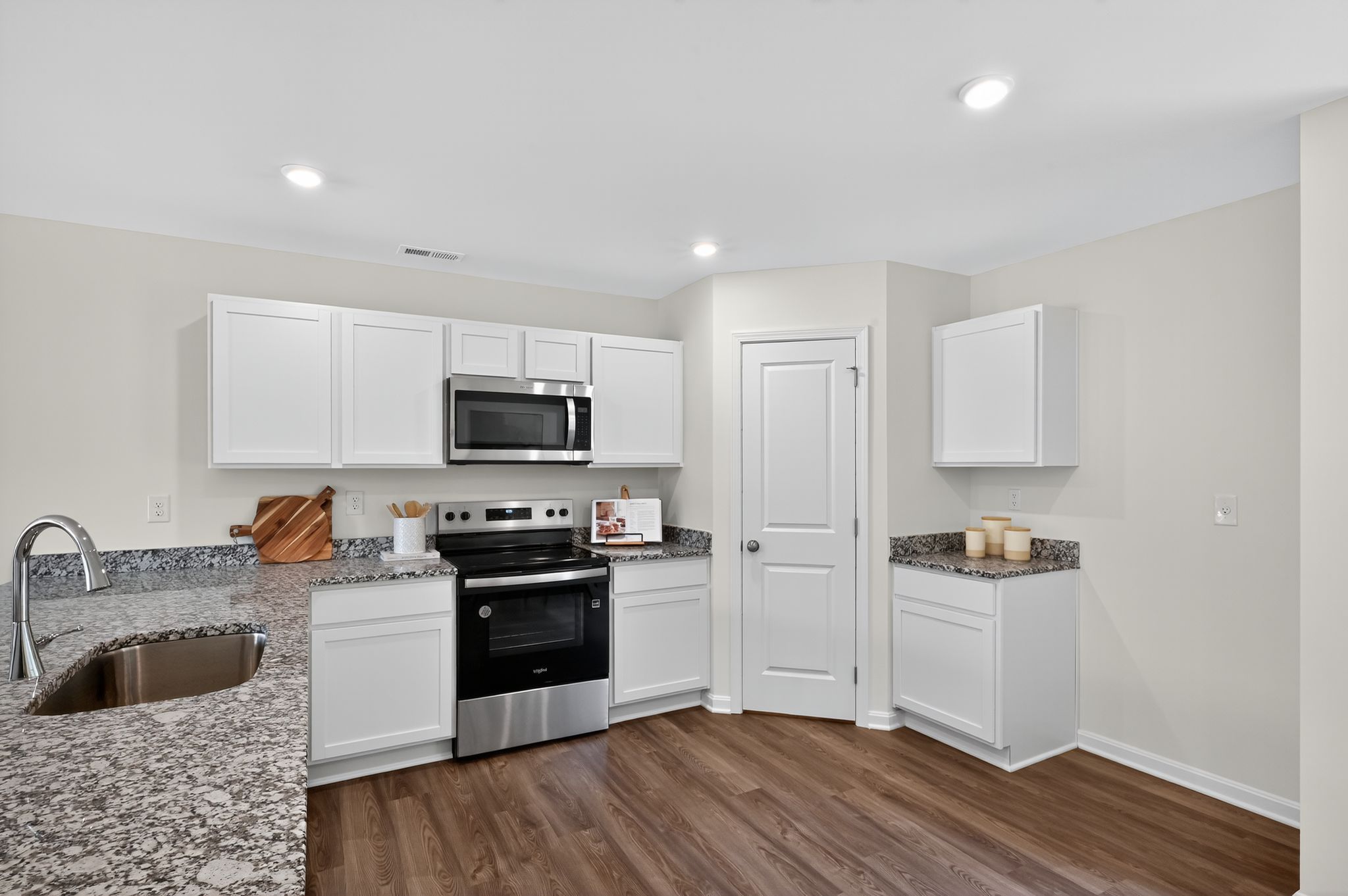 A kitchen with white cabinets.
