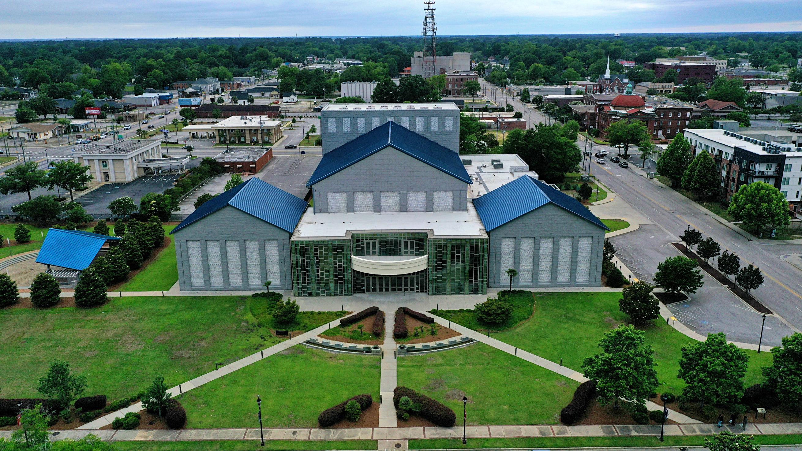 A large building with a green lawn.